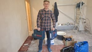 Michał Toussaint trzymający walizki z narzędziami BOSCH gotowa do renowacji futryn
