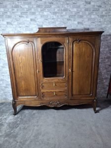 Klasyczny kredens z przeszklonym segmentem, eleganckimi zdobieniami i stylowymi nogami.