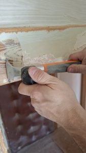 Ręczne usuwanie farby ze starej futryny skrobakiem Bahco