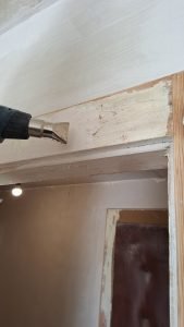 Usuwanie starej farby z futryny za pomocą opalarki